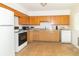 Traditional kitchen with wood cabinets, white appliances, and bright natural light at 814 N Noble St, Greenfield, IN 46140