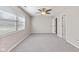 Bright bedroom with neutral walls, plush carpet, ceiling fan, and ample natural light from a window at 834 Delray Dr, Indianapolis, IN 46241