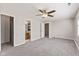 Spacious bedroom with gray carpet, ceiling fan and access to a bathroom at 834 Delray Dr, Indianapolis, IN 46241