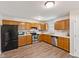 Well-lit kitchen with oak cabinets, modern stainless steel appliances, and stylish vinyl flooring at 834 Delray Dr, Indianapolis, IN 46241
