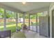 The screened porch features seating, an outdoor cabinet, and views to the backyard area with a grill at 834 Delray Dr, Indianapolis, IN 46241