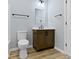 Bathroom with wood vanity, quartz countertop, modern fixtures, and wood laminate flooring at 8355 Fieldfare Way, Indianapolis, IN 46237