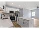 Bright kitchen features white cabinets, stainless steel appliances, a center island, and modern pendant lighting at 8355 Fieldfare Way, Indianapolis, IN 46237