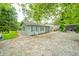 Exterior view of a cozy home with a gravel driveway, surrounded by trees, offering a rural charm at 8842 S Pleasure Valley Rd, Waldron, IN 46182
