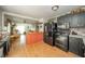 Well lit kitchen featuring modern appliances, black cabinets, and wood floors throughout at 8842 S Pleasure Valley Rd, Waldron, IN 46182
