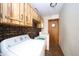 Functional laundry room with brick accent wall, wooden cabinets, and modern washer and dryer at 8842 S Pleasure Valley Rd, Waldron, IN 46182