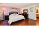 The spacious bedroom features hardwood floors, a cozy bed, bedside tables, and modern artwork at 9022 Hosta Way, Camby, IN 46113