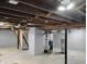 Unfinished basement featuring concrete floors, painted brick support, and open ceiling at 94 N Routiers Ave, Indianapolis, IN 46219