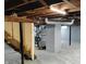 Unfinished basement showing open ceiling, gray painted brick supports, and concrete flooring at 94 N Routiers Ave, Indianapolis, IN 46219