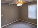 This bedroom has neutral walls, a ceiling fan, carpet, and a window with blinds at 94 N Routiers Ave, Indianapolis, IN 46219