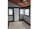 Neutral bedroom featuring tile floor, ceiling fan, exterior door and multiple windows at 94 N Routiers Ave, Indianapolis, IN 46219
