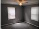 This bedroom has neutral paint, ceiling fan and two windows with blinds at 94 N Routiers Ave, Indianapolis, IN 46219