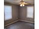 This bedroom has neutral walls, a ceiling fan, carpet, and windows with blinds at 94 N Routiers Ave, Indianapolis, IN 46219