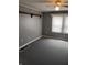 Bedroom with gray walls and black floors featuring window views and decorative shelving at 94 N Routiers Ave, Indianapolis, IN 46219