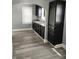 Modern kitchen features dark cabinets, granite countertops, stainless sink and wood look flooring at 94 N Routiers Ave, Indianapolis, IN 46219