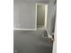 Room with gray walls and dark floor showing a doorway leading into an adjacent room at 94 N Routiers Ave, Indianapolis, IN 46219