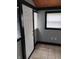 Small room with tiled flooring, light gray walls, and an exterior door and windows at 94 N Routiers Ave, Indianapolis, IN 46219