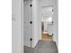 Hallway leading into a bathroom with grey walls, wood flooring, and white trim at 9724 Brooks Dr, Fishers, IN 46055