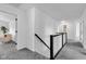 Upstairs hallway with carpet and black railings and multiple doorways to rooms at 9724 Brooks Dr, Fishers, IN 46055
