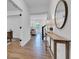 Bright hallway with wood floors, a decorative table, and an open view to the living area at 9724 Brooks Dr, Fishers, IN 46055