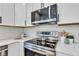 Modern kitchen featuring stainless steel appliances, white cabinets, subway tile backsplash, and quartz countertops at 9724 Brooks Dr, Fishers, IN 46055