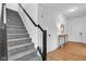 Carpeted staircase with black handrail leads to the second floor, next to hardwood flooring at 9724 Brooks Dr, Fishers, IN 46055