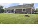 Spacious backyard with fire pit, red brick exterior, and lush green grass at 1016 W Creek Ridge Dr, Fountaintown, IN 46130