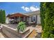 Backyard patio with ample seating, featuring a covered area and steps to the yard at 10758 Cyrus Dr, Indianapolis, IN 46231