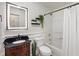 Bathroom featuring a sink vanity, toilet, shower and tub combo, and decorative mirror at 10758 Cyrus Dr, Indianapolis, IN 46231
