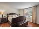Charming bedroom with a dark wood bed frame, complementary furniture, and natural light at 10758 Cyrus Dr, Indianapolis, IN 46231