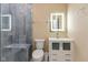 Modern bathroom featuring a tiled shower, tiled floors, and a lighted mirror above the vanity at 1122 W 35Th St, Indianapolis, IN 46208
