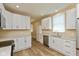 The updated kitchen has white cabinetry, stainless appliances, new countertops, and laminate flooring at 1122 W 35Th St, Indianapolis, IN 46208