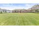 Beautiful backyard showcasing a manicured lawn and a brick home with a covered patio area, ideal for outdoor gatherings at 1165 Maclaren Ct, Franklin, IN 46131