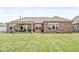 Brick home exterior featuring a well-maintained lawn, backyard patio, and a relaxing hot tub, great for entertaining at 1165 Maclaren Ct, Franklin, IN 46131