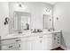 Modern bathroom featuring double sinks, white cabinets, and dark hardware at 1165 Maclaren Ct, Franklin, IN 46131