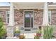 Charming front door with a wreath, flanked by stone pillars and potted plants at 1165 Maclaren Ct, Franklin, IN 46131