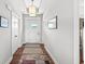 Bright entrance featuring wood floors, a white front door with transom window, and a modern light fixture at 1165 Maclaren Ct, Franklin, IN 46131