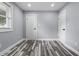 Empty bedroom with wood-look flooring, white trim, fresh paint and a window allowing natural light at 1346 Carroll White Dr, Indianapolis, IN 46219