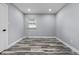 Empty bedroom featuring wood-look floors, window, fresh paint and ample electrical outlets at 1346 Carroll White Dr, Indianapolis, IN 46219