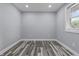 Empty bedroom with wood-look flooring, a window bringing in natural light, and fresh paint at 1346 Carroll White Dr, Indianapolis, IN 46219