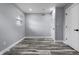 Empty bedroom featuring wood-look floors, window, fresh paint, two doors, and modern hardware at 1346 Carroll White Dr, Indianapolis, IN 46219