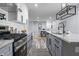 Open kitchen featuring stainless steel appliances, gray cabinets, white subway tile, and an island with pendant lighting at 1346 Carroll White Dr, Indianapolis, IN 46219