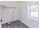 Compact laundry room with gray vinyl flooring, white walls, a window and functional shelving at 1511 E 20Th St, Muncie, IN 47302