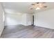 Bright living room featuring modern gray wood flooring, neutral paint, ceiling fan and an interior door at 1511 E 20Th St, Muncie, IN 47302
