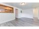 Cozy living room featuring gray vinyl flooring, neutral paint and a wood trimmed passthrough to the kitchen at 1511 E 20Th St, Muncie, IN 47302