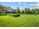 The backyard features a well-manicured lawn, mature trees, and lush landscaping at 160 Scranton Ct, Zionsville, IN 46077