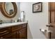 This bathroom features an oval mirror, a wood cabinet with granite countertop, and a seashell-themed framed picture at 160 Scranton Ct, Zionsville, IN 46077