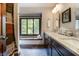 Bathroom featuring double sinks, granite counters, wood cabinets, and a window with backyard views at 160 Scranton Ct, Zionsville, IN 46077
