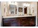 Bathroom vanity with granite counters, double sinks, wood cabinets, and decorative elements at 160 Scranton Ct, Zionsville, IN 46077