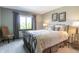Bright bedroom with a wrought iron bed, neutral walls, a large window and decoratively framed art at 160 Scranton Ct, Zionsville, IN 46077